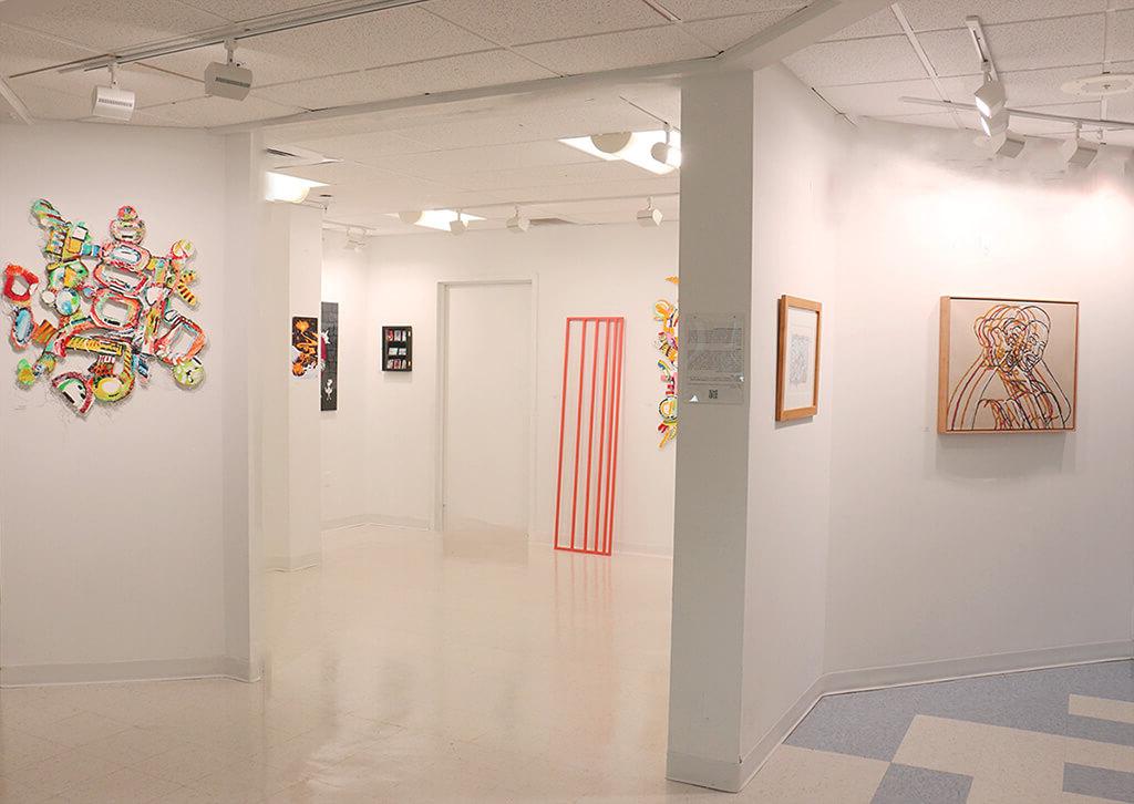 A wide-angle view of an art gallery space with several 油漆ings and a sculpture.